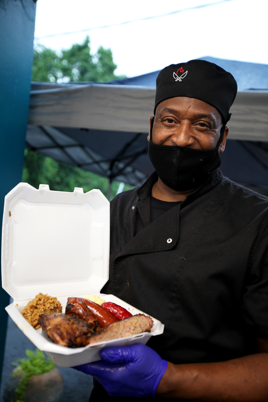 A photo of a man holding a tray of barbecue