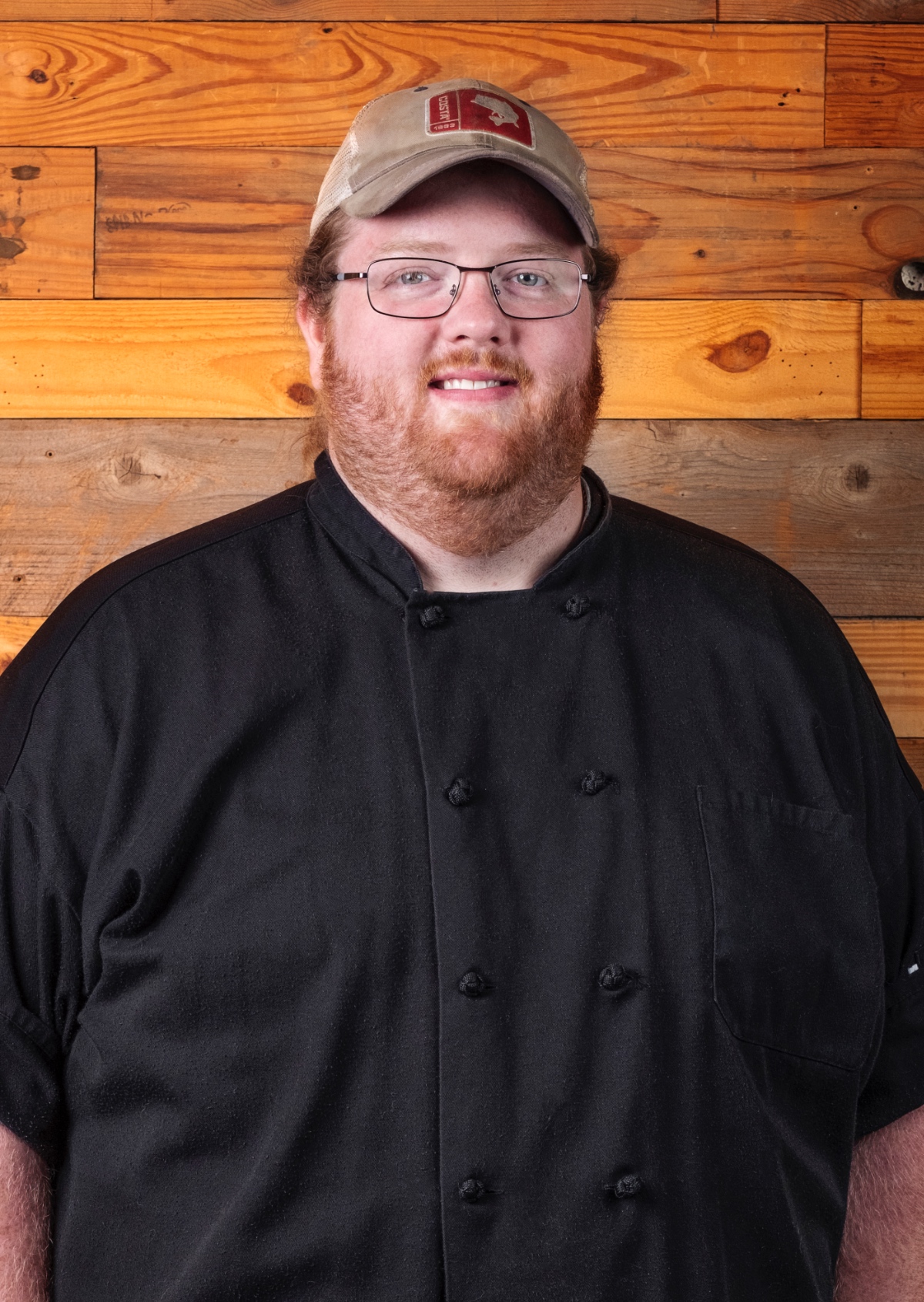 A photo of Chef Nick Simon, a chef with red hair who is wearing glasses