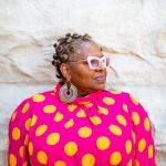 A photo of author and poet Crystal Wilkinson shows the author wearing a pink and yellow blouse